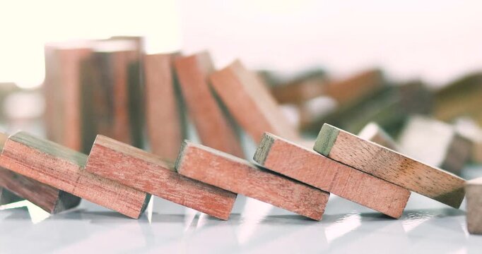Wooden dominoes falling in sequence, chain reaction, risk, business strategy, decision making, failure, change, crisis, leadership, and cause-and-effect concepts