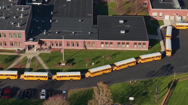 Yellow school buses lined up outside an American public school in the United States