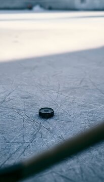 Winter stillness a poised hockey puck awaits action on an icy rink bathed in soft light