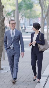 歩きながら話すビジネスマンたち