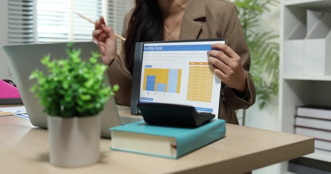 Businesswoman presenting financial reports and performance charts during business meeting, explaining data analysis, company results and strategic planning for finance, management and corporate growth