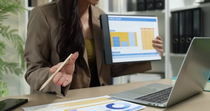 Businesswoman presenting financial reports and performance charts during business meeting, explaining data analysis, company results and strategic planning for finance, management and corporate growth