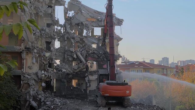 Slow motion: demolition of building, excavator with hydraulic crusher is tearing down the old typical Turkish multi-storey apartment, residential building in Istanbul, Turkey