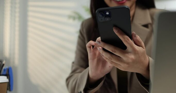 Businesswoman using a smartphone to review financial information, manage business communication, and access digital reports in a modern office, supporting mobile productivity and business management.