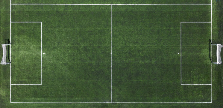 Top down aerial drone view of a soccer football pitch with green turf and white field lines