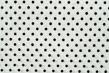 Black polka dots creating a repetitive pattern on a white textile surface © Floren Horcajo