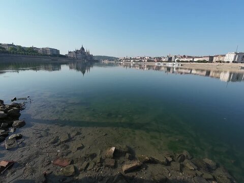 Low water level of the Danube river in Budapest at sunrise, featuring the Liberty Bridge and the uncovered Inseg Rock, and the Margit bridge and the island. 02.08.2026.