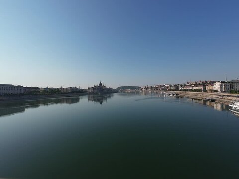 Low water level of the Danube river in Budapest at sunrise, featuring the Liberty Bridge and the uncovered Inseg Rock, and the Margit bridge and the island. 02.08.2026.