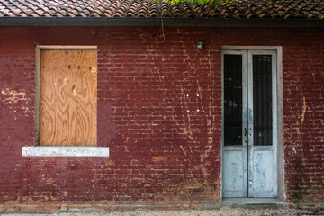 La facciata di una casa abbandonata con una finestra chiusa con una tavola di legno © Andrea Vismara