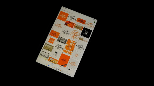 Tablet screen view with various sized Hermes logos, on a black background, August 1, 2026