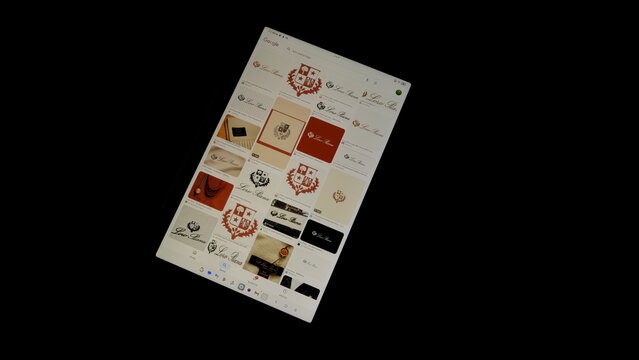 Tablet screen view with various sized Loro Piana logos, on a black background, August 1, 2026