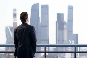 Fototapeta premium Businessman Viewing a Bright Modern City Skyline from a Balcony, Symbolizing Future Vision, Ambition, Research, and Creative Professional Growth.