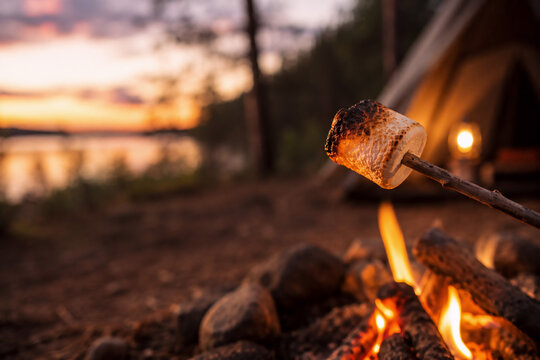 Ger&ouml;steter Marshmallow &uuml;ber dem Lagerfeuer beim Camping am See