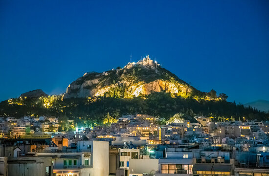 A view at night over the rooftops of Athens towards the Lycabettus Hill in Athens, Greece in early summertime