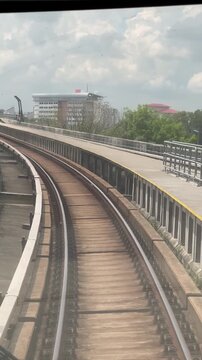 First-person front window view from the lead car of an automated subway train running along elevated railway tracks on the yellow MRT Putrajaya Line in Kuala Lumpur, Malaysia. 