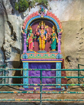 Kuala Lumpur, Malaysia - February 18, 2025: Colorful shrine featuring Hindu deity Lord Murugan with his consorts Valli and Devasena inside the limestone caverns at the Batu Caves temple complex