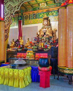 Golden Mazu statue inside the ornate Thean Hou Temple in Kuala Lumpur, Malaysia, featuring traditional religious architecture and decorative prayer altars with offerings