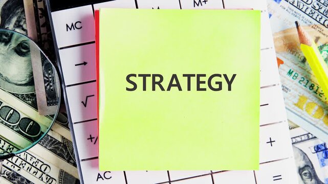 Sticky notes display the word strategy as it develops. The setting includes tools and cash, showcasing a work or planning environment