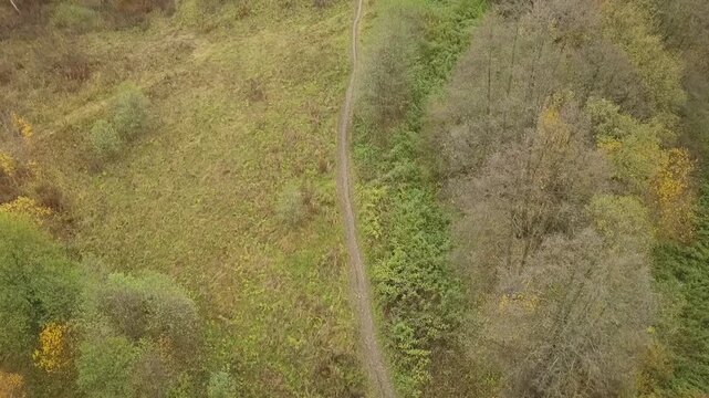 Drone rising from autumn path toward Pushchino skyline