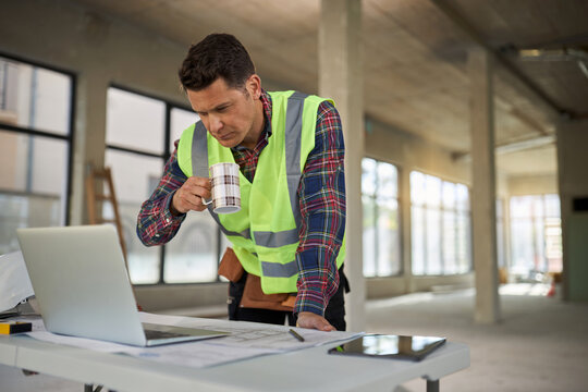 Manual worker analyzing housing project on a computer during home renovation process