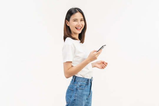 Smiling young Asian businesswoman using smartphone and chatting online isolated on white studio background for communication.