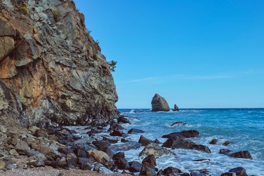 Dramatic rocky Mediterranean coastline with turquoise sea and weathered coastal cliffs