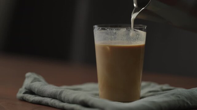 Slow motion making ice latte at home closeup shot