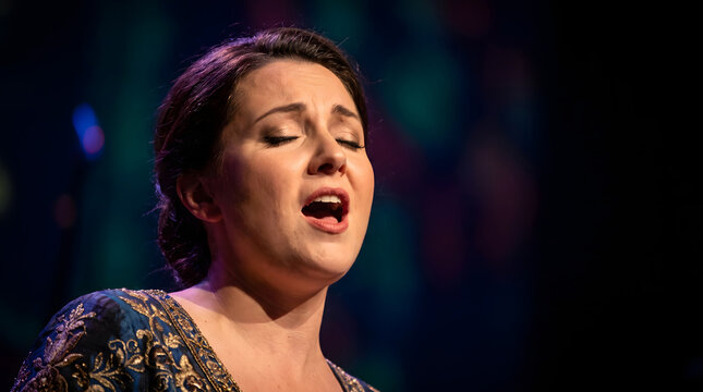 Female singer passionately performing with eyes closed in a stage close-up shot
