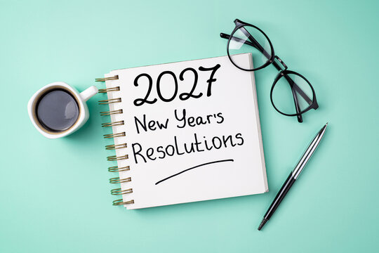 New year resolutions 2027 on desk. 2027 resolutions list with notebook, coffee cup on table. Goals, resolutions, plan, action, checklist concept. New Year 2027 template, copy space