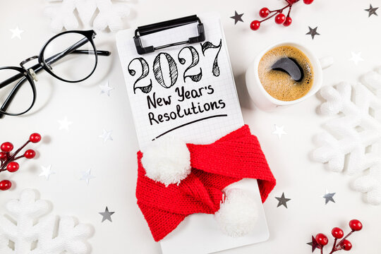 New year resolutions 2027 on desk. 2027 goals list with notebook, coffee cup on white table. Resolutions, plan, goals, action, checklist, idea concept. New Year 2027 resolutions, copy space