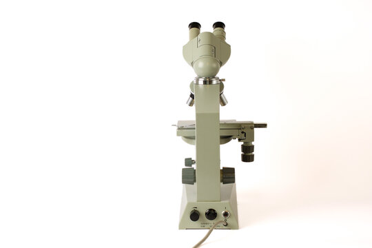 Rear view of a laboratory compound microscope isolated on a white background. Professional optical instrument used for biological research, laboratory diagnostics and scientific observation.