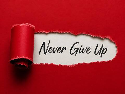 Never give up inspirational message revealed through torn red paper with white background