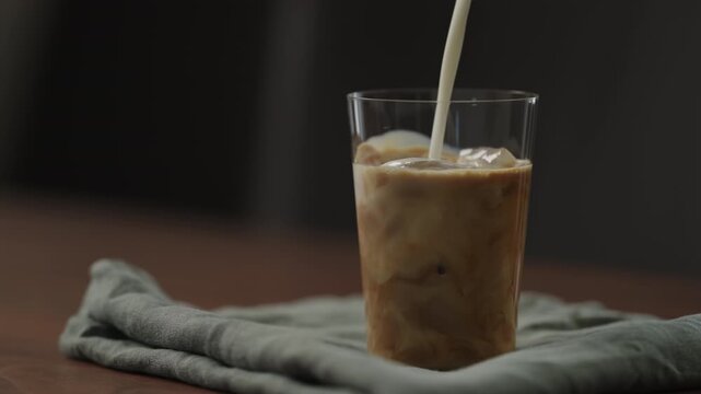 Slow motion making ice latte at home closeup shot