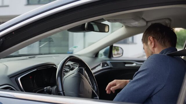 Man fastening seat belt before driving