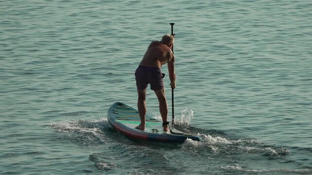 Man paddleboarding on calm water