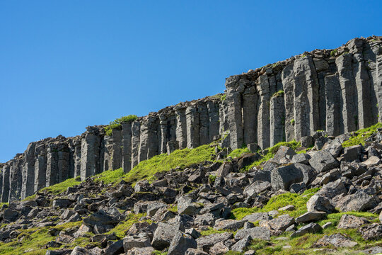 Majestic Gerduberg basalt columns cliff under a clear blue sky in Iceland.
