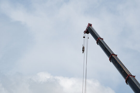 Closeup Mobile crane boom with wire ropes against blue sky 