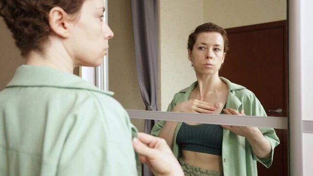 mirror portrait of a cancer patient gently resting her hand near the chemo port, showing thoughtful self observation, treatment experience and quiet strength at home