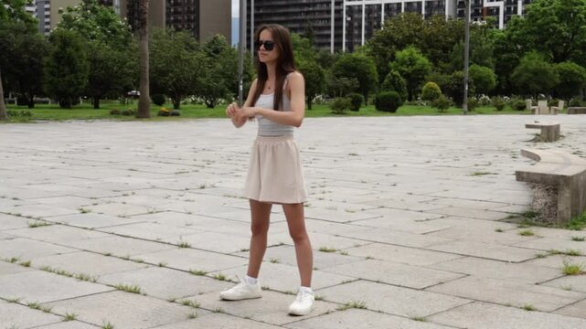 teen girl holds a deep lunge stretch in an urban park, showing lower body mobility, beginner fitness and healthy movement outdoors in a modern urban public space