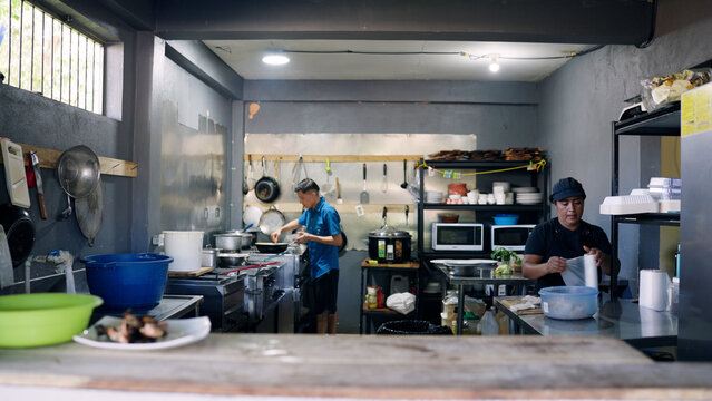 Two skilled chefs preparing fresh ingredients and cooking meals in a vibrant, authentic commercial kitchen setting