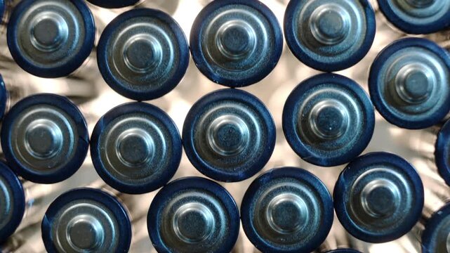 Lots of alkaline batteries AA illuminated from below close-up top view, energy technology background