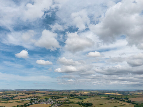 Aerial drone view of rural Cornish countryside with blue cloudy skies and patchwork fields in Lanreath England United Kingdom