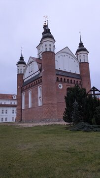Exterior View of Historic Orthodox Monastery Church of the Annunciation in Supraśl Poland Featuring Fortified Gothic Brick Architecture with Corner Towers and Crosses under Twilight Sky for Travel Her
