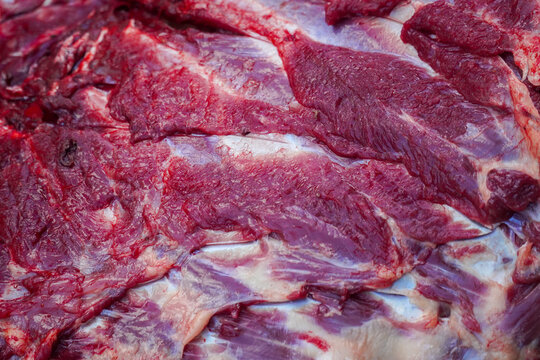 Fresh raw meat cuts with rich red color and marbling displayed close-up for culinary or food production use. High detail texture suitable for restaurant, butcher shop, or cooking concept visuals.