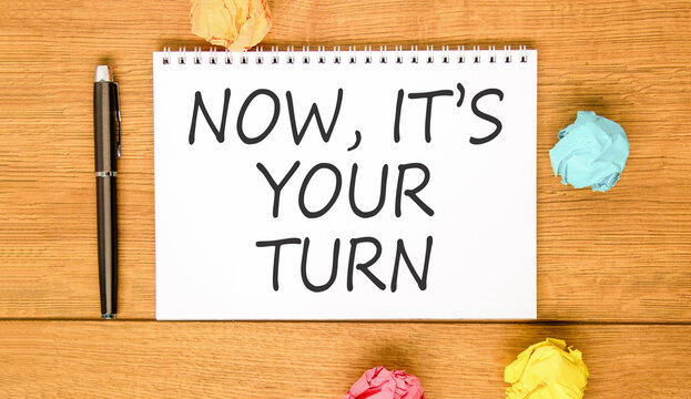 Now it's your turn symbol. Concept words Now it's your turn on beautiful white note. Beautiful wooden background. Colored paper. Business Now it's your turn motivational support concept. Copy space