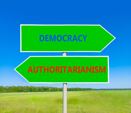 Democracy or authoritarianism symbol. Concept words Democracy Authoritarianism on beautiful green road sign. Beautiful blue sky background. Business democracy authoritarianism concept. Copy space