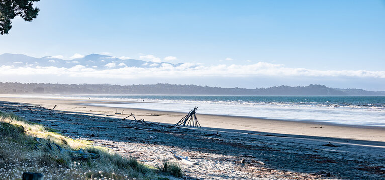 Kina Beach, Ruby Bay, Sinus Tasmanianus, Tasman, Neuseeland, Oceanus Pacificus, Sandstrand mit Treibholz und Blick auf die Bergkette im Panoramablick