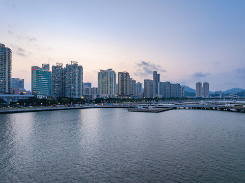 Zhuhai Sun Moon Shell waterfront city skyline at dusk with modern high-rise buildings and calm water reflections
