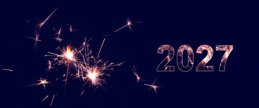 two burning sparklers with glowing 2027 isolated on dark blue background, greeting card for happy new year party, december holiday season or anniversary celebration