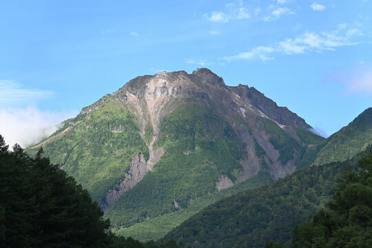 青空に映える険しい山肌と緑豊かな山岳風景